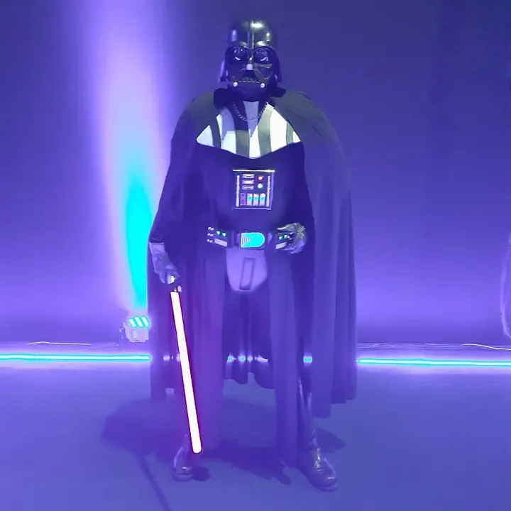 Wayne Mendes como Darth Vader, com luz roxa ao fundo